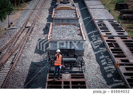 Engineer under discussion inspection and checking construction process railway switch and checking work on railroad station .Engineer wearing safety uniform and safety helmet in work. 83664032