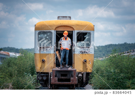 Engineer under discussion inspection and checking construction process railway switch and checking work on railroad station .Engineer wearing safety uniform and safety helmet in work. 83664045