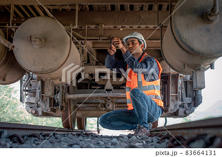 Engineer under discussion inspection and checking construction process railway switch and checking work on railroad station .Engineer wearing safety uniform and safety helmet in work. 83664131