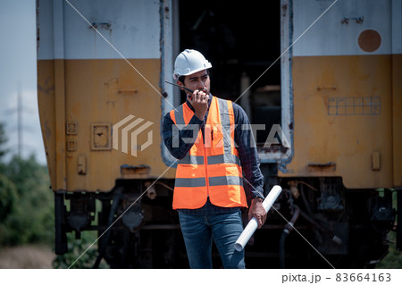 Engineer under discussion inspection and checking construction process railway switch and checking work on railroad station .Engineer wearing safety uniform and safety helmet in work. Engineer under discussion inspection and checking construction process railway switch and checking work on railroad station .Engineer wearing safety uniform and safety helmet in work. 83664163