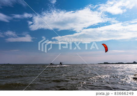 A kite surfer sailing at sea. Storm waves and Windsurfing. Surfer on the sea A kite surfer sailing at sea. Storm waves and Windsurfing. Surfer on the sea 83666249