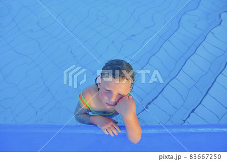 Cute little girl in the swimming pool. Portrait of little cute girl in the swimming pool. Sunny summer day. Summer and happy chilhood concept. Copy space 83667250