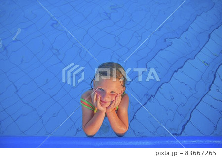 Cute little girl in the public swimming pool. Portrait of little cute girl in the swimming pool. Sunny summer day. Summer and happy chilhood concept. Copy space 83667265