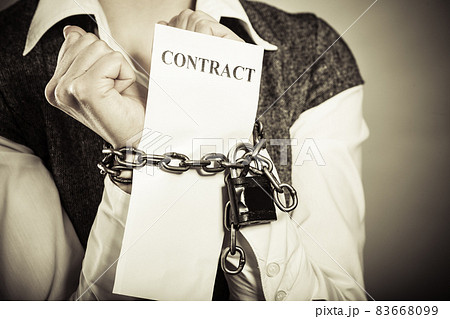 businesswoman with chained hands holding contract businesswoman with chained hands holding contract 83668099