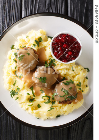 Lihapullat Traditional Finnish Meatballs with mashed potatoes and lingonberry jam close-up in a plate. vertical top view 83669843
