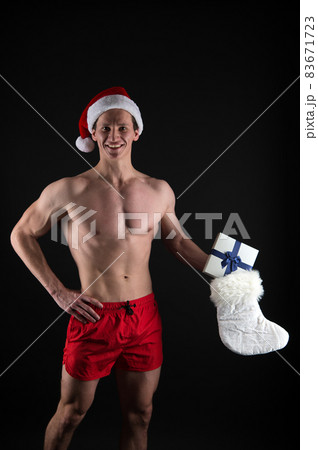 Stocking stuffers. Muscular man wear santa claus hat. Stocking stuffers. Muscular man wear santa claus hat. 83671723