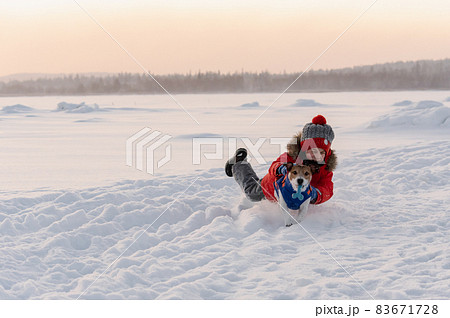 Friends having fun outdoors during evening dog walk on pleasant winter day 83671728