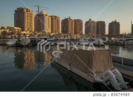 Porto Arabia Marina in The pearl Doha, Qatar sunset  shot showing luxurious yachts docked at the marina with  residential buildings in background. 83674484