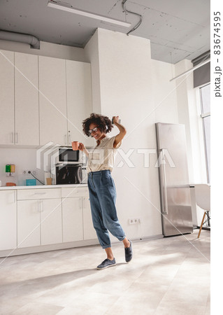 Happy young lady in glasses enjoying the music Happy young lady in glasses enjoying the music 83674595