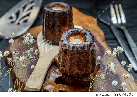De Bordeaux Recipe is a small pastry with rum and vanilla on a wooden plate. 83674900