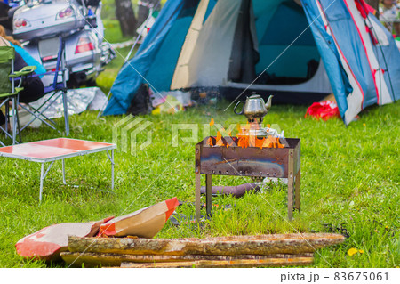 Camping outdoors - tents, equipment and cooking. Cooking over a campfire on the Camping. Camping outdoors - tents, equipment and cooking. Cooking over a campfire on the Camping. 83675061