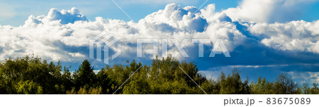 Landscape with beautiful fluffy clouds on a blue sky. Banner format for design. Landscape with beautiful fluffy clouds on a blue sky. Banner format for design. 83675089