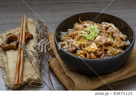 Japanese pork rice bowl with egg and onion (Donburi) served with pickled ginger and green tea. Japanese pork rice bowl with egg and onion (Donburi) served with pickled ginger and green tea. 83675125