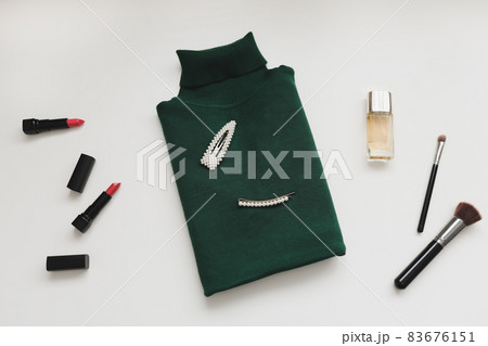 Overhead view of women's knitted sweater, perfume and accessories on white background. Flat lay, top view. Stylish women clothes Overhead view of women's knitted sweater, perfume and accessories on white background. Flat lay, top view. Stylish women clothes 83676151