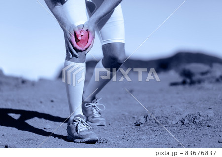 Knee pain athlete sports injury runner man running on trail race with sport health problem holding painful leg. ACL ligament tear is one of the most common knee ligament injuries. 83676837