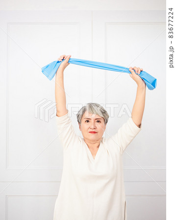 Senior asian woman doing exercises with resistance band at home. Senior asian woman doing exercises with resistance band at home. 83677224