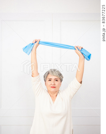 Senior asian woman doing exercises with resistance band at home. Senior asian woman doing exercises with resistance band at home. 83677225
