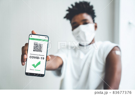 Young Asian woman shows vaccine passport on mobile phone 83677376