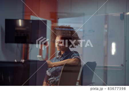 Happy young lady holding mobile phone in the office 83677398