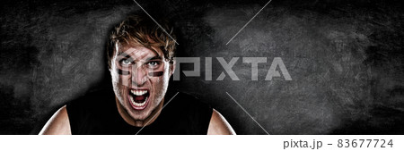 American football player screaming on black chalkboard texture background copy space for advertising. Panoramic banner blackboard with man athlete ready to play face paint black eye. American football player screaming on black chalkboard texture background copy space for advertising. Panoramic banner blackboard with man athlete ready to play face paint black eye. 83677724