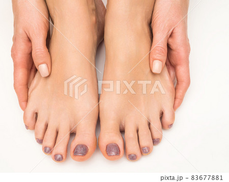 Hands and feet of a young girl with manicure and pedicure on a white background. Close-up. 83677881