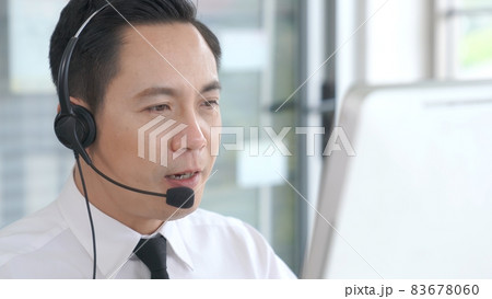 Businessman wearing headset working actively in office 83678060