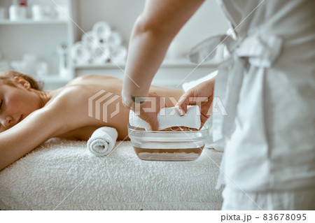 confident female specialist is doing relaxing body massage for beautyful slim caucasian lady at minimalistic spa salon 83678095