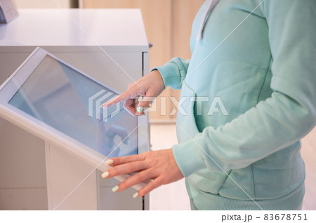 Faceless woman touching the screen of a self-service device in a store. Device store navigator. Self purchase. 83678751