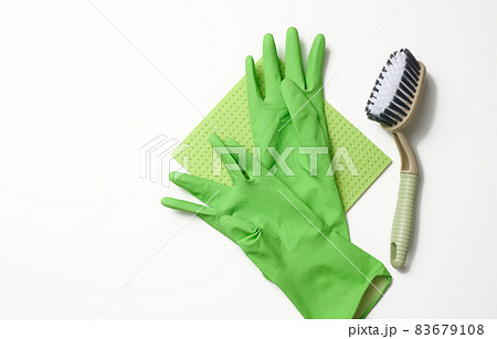 green rug, rubber gloves for cleaning, brushes on a white background, flat lay. 83679108