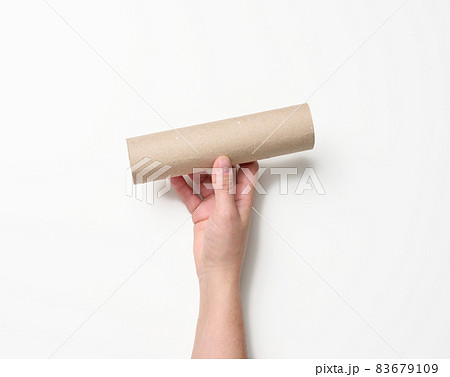 female hand holds a paper tube from under used napkins on a white background female hand holds a paper tube from under used napkins on a white background 83679109