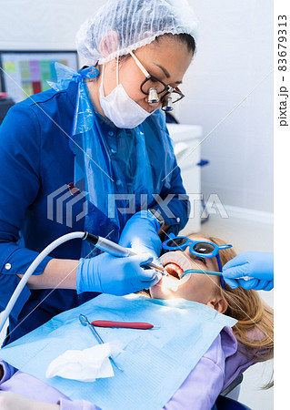 kid with oral dilator at dentist's appointment. treatment of teeth kid with oral dilator at dentist's appointment. treatment of teeth 83679313