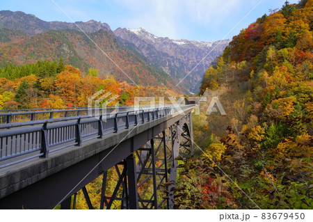 紅葉した奥飛騨温泉郷の北アルプス大橋と冠雪した笠ヶ岳 83679450