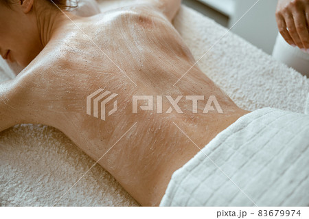 confident female specialist is doing relaxing body massage for beautyful slim caucasian lady at minimalistic spa salon 83679974