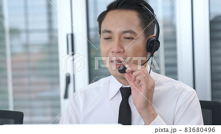 Businessman wearing headset working actively in office Businessman wearing headset working actively in office 83680496