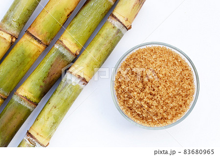 Sugar cane with brown sugar on white background 83680965