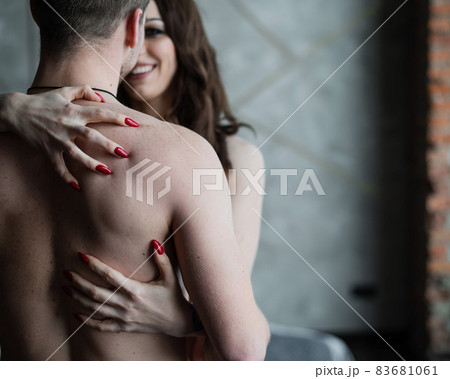 Female hands on the bare back of an unrecognizable man. A young couple cuddles in the bedroom. Love and relationship. Female hands on the bare back of an unrecognizable man. A young couple cuddles in the bedroom. Love and relationship. 83681061