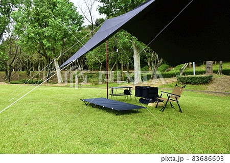 ソロキャンプイメージ　ブラックのタープとキャンプギア 83686603