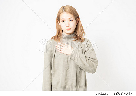 胸に手を当てるセーターを着た若い女性 胸に手を当てるセーターを着た若い女性 83687047
