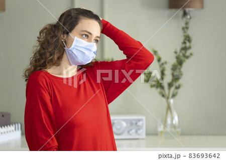 Young woman wearing a mask to protect herself against the coronavirus at home 83693642