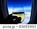 飛行機の機窓から見える空とビジネスクラスのシャンパン 83693903