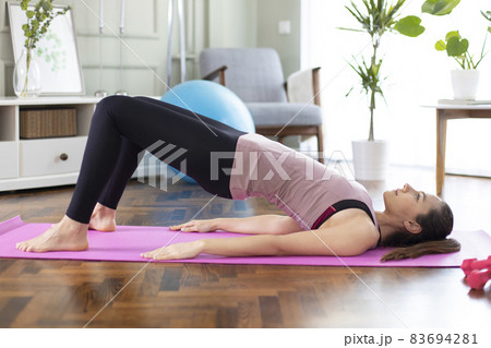 Beautiful sporty woman in sportswear doing exercises to build muscles at home 83694281