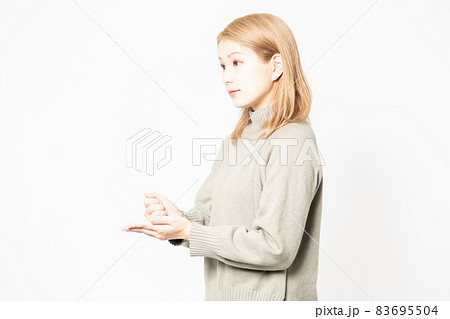 納得のジェスチャーをするセーターを着た若い女性 83695504