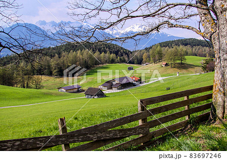 Tirol, Oostenrijk. April 2010. Hill landscape in Austria with snow-capped mountain peaks in the background. Tirol, Oostenrijk. April 2010. Hill landscape in Austria with snow-capped mountain peaks in the background. 83697246
