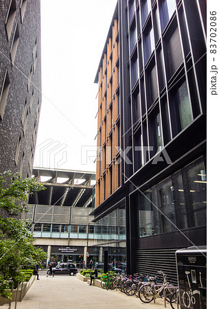 ロンドンの街並み　近代的な建物とレンガ造りの歴史的な建物が両脇に立つ細道 83702086