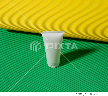 empty white plastic tubes for cosmetics on a green yellow background. Packaging for cream, gel, serum, advertising and product promotion, mock up empty white plastic tubes for cosmetics on a green yellow background. Packaging for cream, gel, serum, advertising and product promotion, mock up 83705032