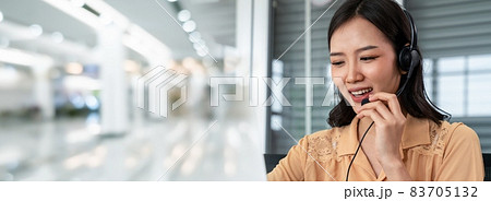 Office worker wearing headset working actively in office Office worker wearing headset working actively in office 83705132