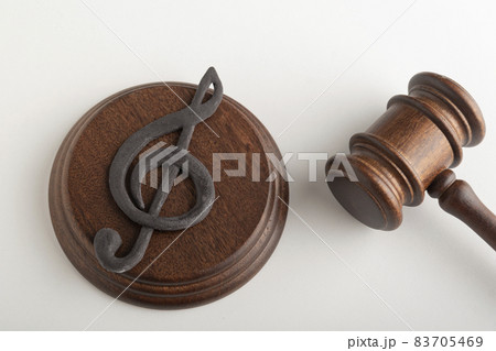 Treble clef and wooden gavel. Music piracy concept. Music Licensing. Violation of musical rights. 83705469