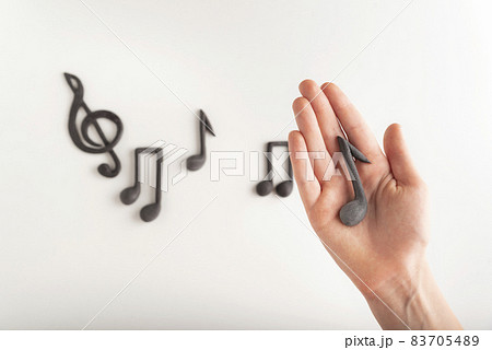 Girl holds musical note treble clef and notes background. Music education concept. 83705489