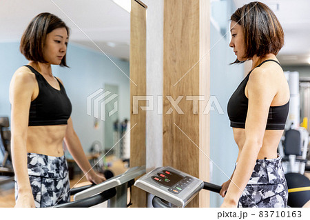 スポーツジムで振動マシンを使う女性 83710163