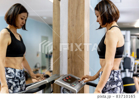 スポーツジムで振動マシンを使う女性 83710165